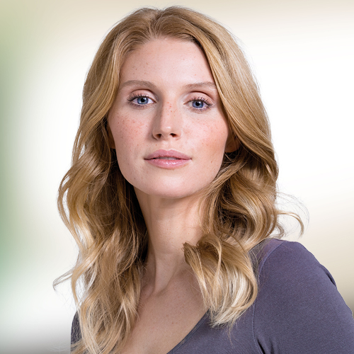 Vrouw met blond, lang haar voor een groenbruine achtergrond