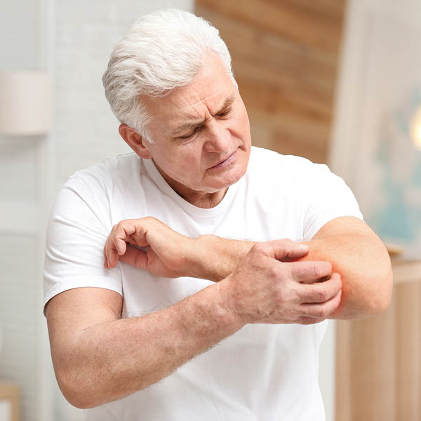 [Translate to Englisch:] Älterer Mann kratzt sich am Ellenbogen