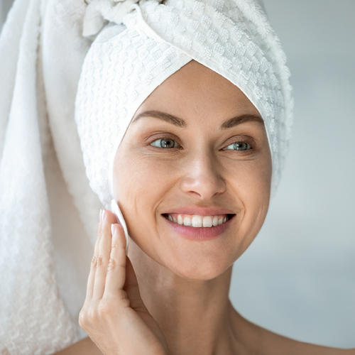 Vrouw reinigt haar gezicht met een wattenschijfje