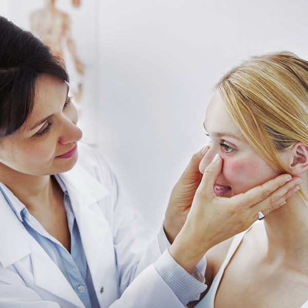 Vrouw met rosacea die een behandeling ondergaat bij de dermatoloog