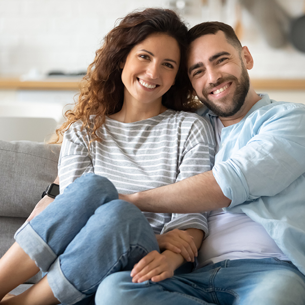 [Translate to Niederländisch:] Ein junges Paar liegt sich lächelnd in den Armen.