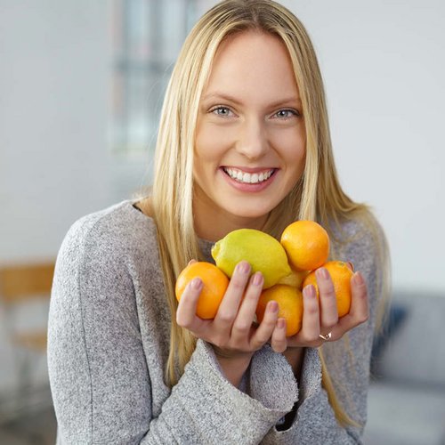 Blonde vrouw met citroenen in haar hand