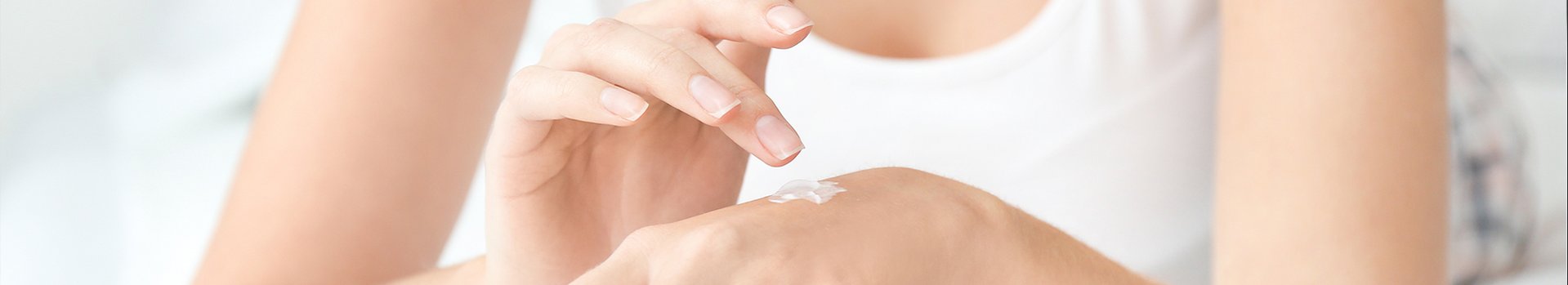 Vrouw test crème
            op de achterkant van haar hand
        
