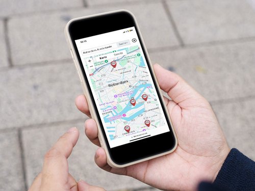 Hand die een smartphone vasthoudt met een stadsplattegrond.