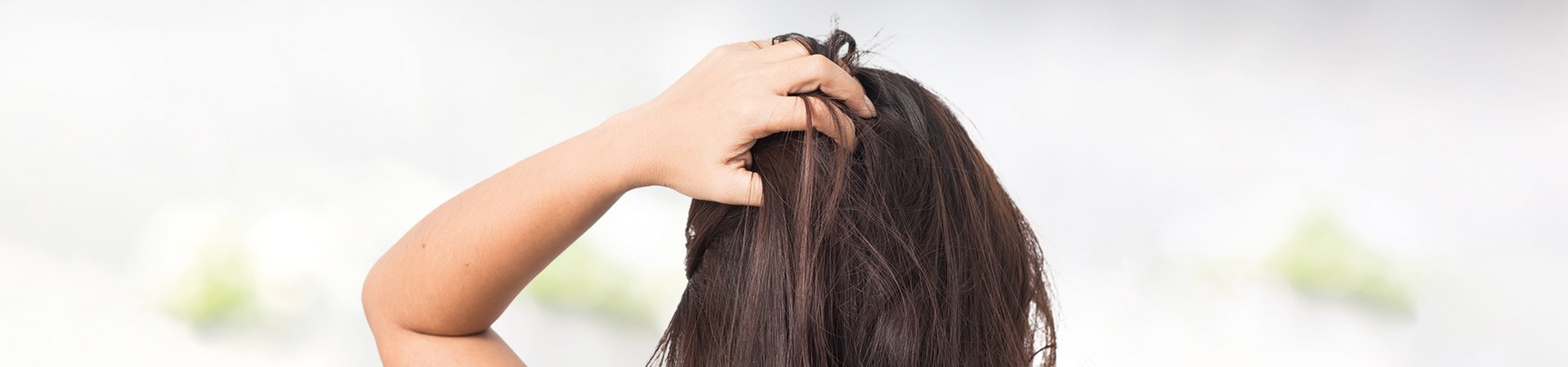 Brunette woman scratches her scalp