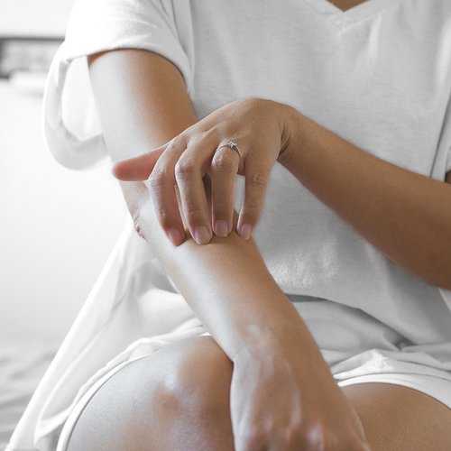 Vrouw krabt aan haar elleboog