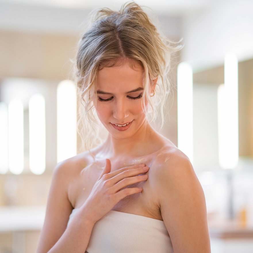 Una donna applica la cura quotidiana al suo décolleté