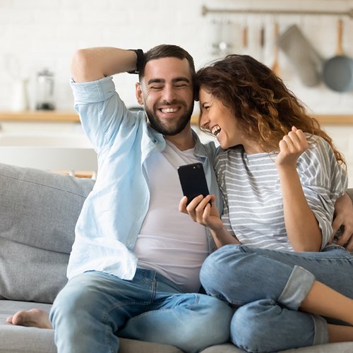 Een jong stel lachend in elkaars armen