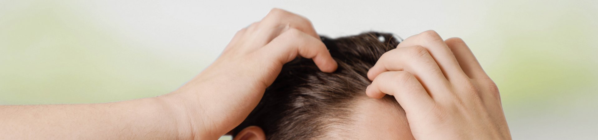 Donkerharige man haalt zijn handen door zijn haar