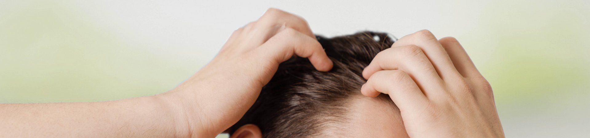 Dark-haired man runs his hands through his hair