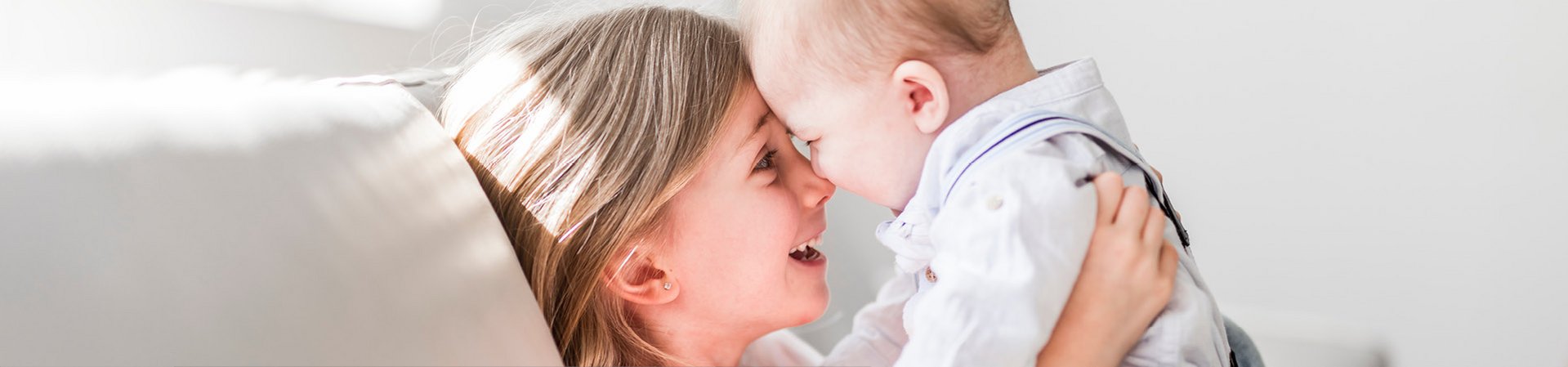 DERMASENCE offre la cura giusta per la pelle dei bambini Sorella maggiore gioca con il fratellino sul divano