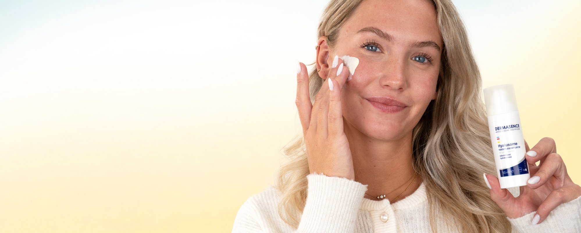 Een blonde vrouw brengt crème aan op haar gezicht