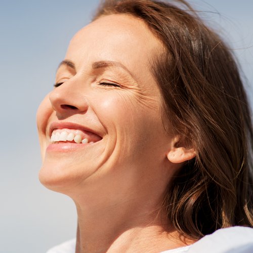 Een vrouw laat haar gezicht in de zon branden