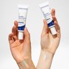Two hands hold the RosaMin Tinted Day Creams light and medium